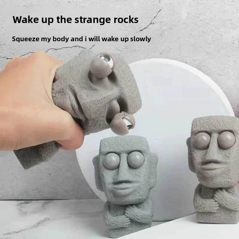 Stone man releases stress toy slowly rebounds soft Moai statue squeeze eyes interested expression relaxes stress children's gift