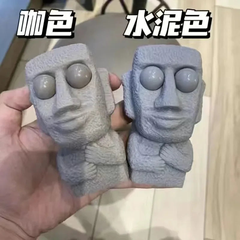 Stone man releases stress toy slowly rebounds soft Moai statue squeeze eyes interested expression relaxes stress children's gift